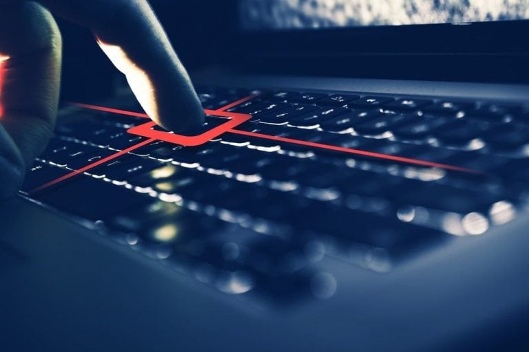 Dedo presionando una tecla resaltada en rojo sobre un teclado, simbolizando la captura de pulsaciones y el robo de información mediante un keylogger.